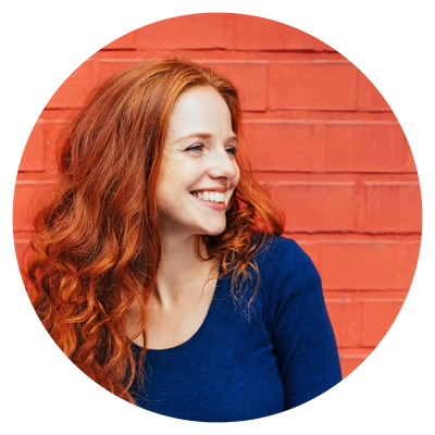 woman with red hair smiling in a blue shirt