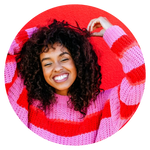 smiling african american woman wearing a red and pink stripe sweater